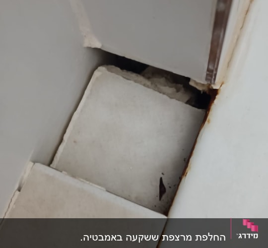 אריחים שבורים עם סימני חלודה בפינה